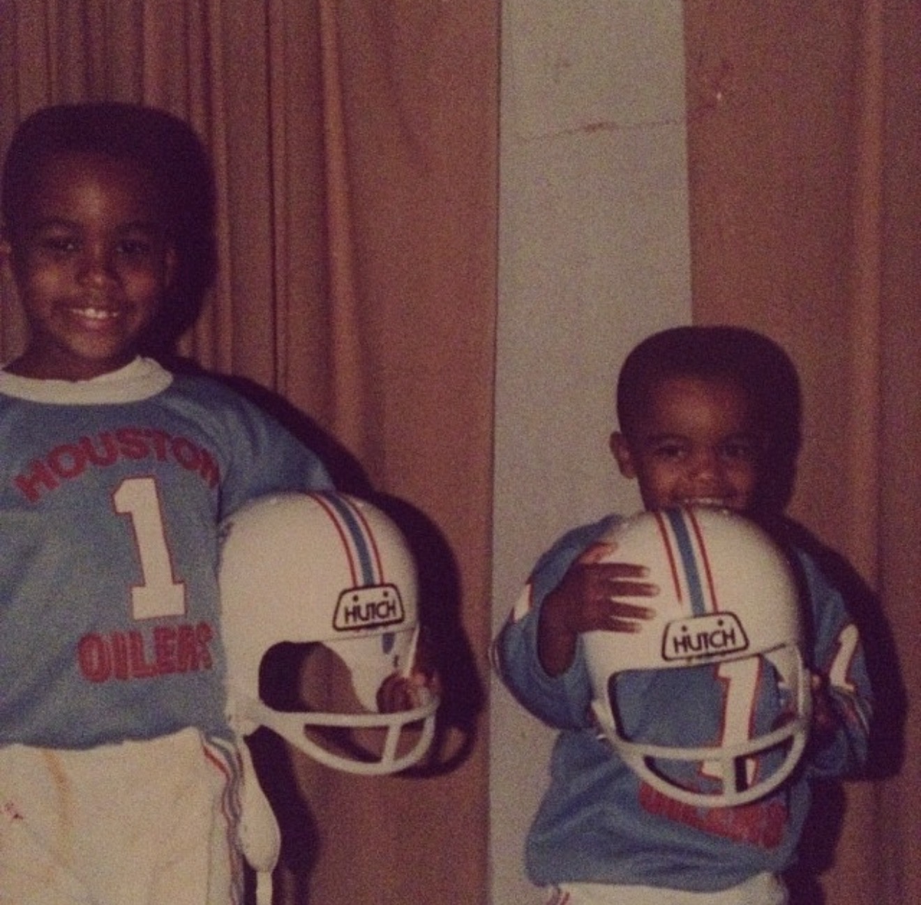 Two young Knighton brothers in Houston Oilers football uniforms holding helmets