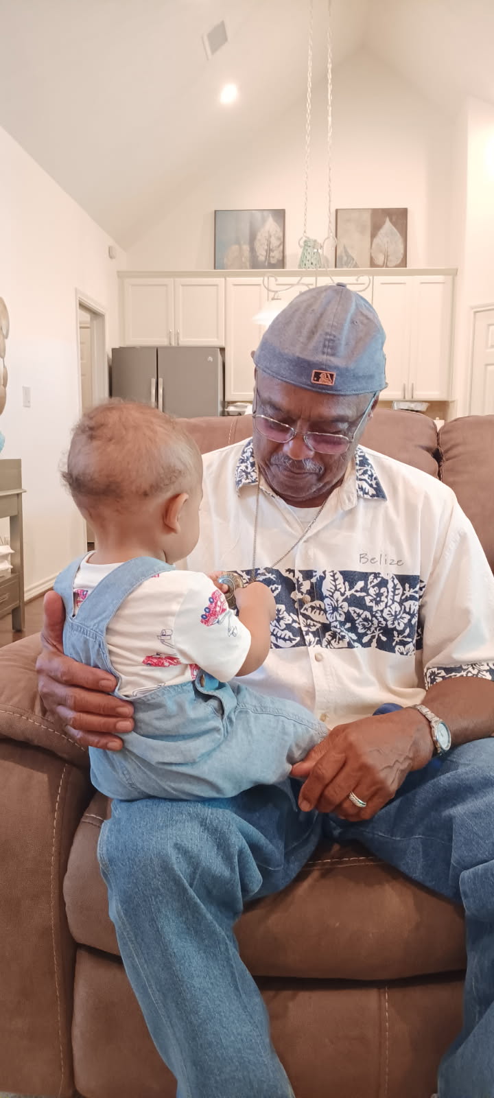 Knighton grandfather holding his grandbaby on a recliner