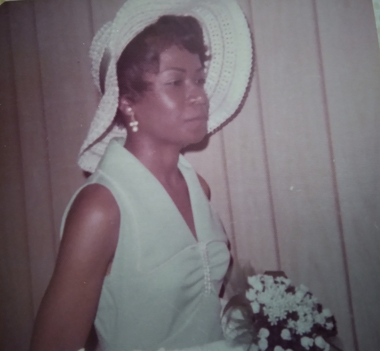 Knighton family member in a white hat holding a bouquet